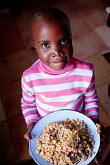 Young girl from Zimbabwe holding a plate of food.